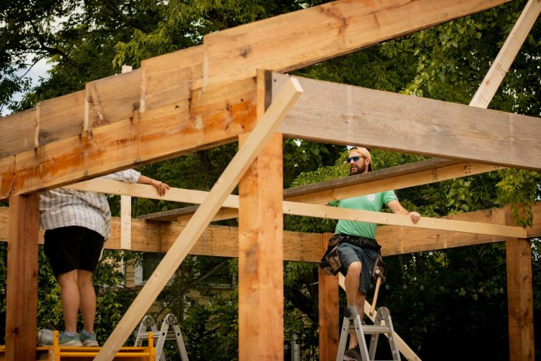 Carpenter on ladder building a garage